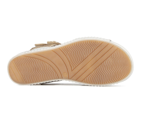 Bottom view of a tan shoe with a white sidewall and wavy tread pattern.