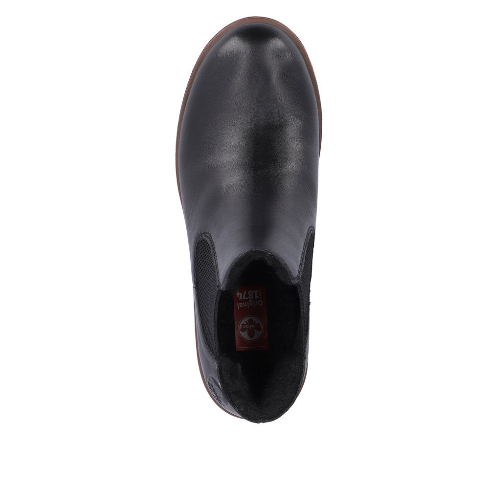 Black leather Chelsea boot with brown sole and elastic side panels, top view.