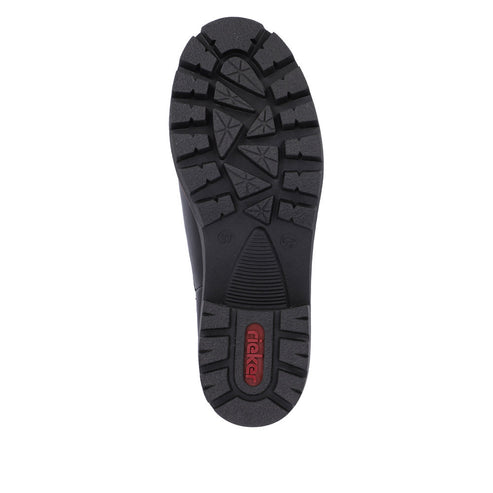 Black shoe sole with thick treads including triangles, parallel lines, and a red logo in the heel area.