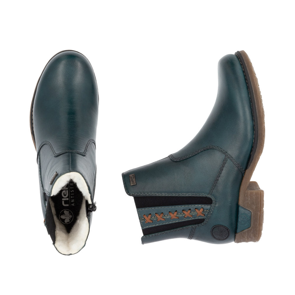 Pair of teal ankle boots, one upright, one showing interior lining, side zipper, decorative stitching.