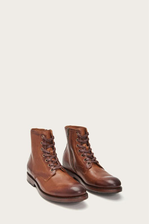 A pair of tan-colored leather boots with laces.