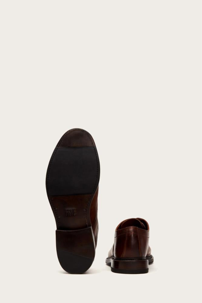 Rear view of a brown leather shoe, showcasing its sole and heel.