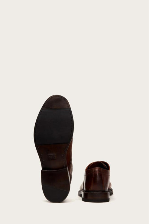 Rear view of a brown leather shoe, showcasing its sole and heel.