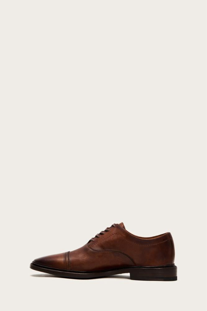 Brown leather oxford dress shoe with cap toe and lace-up closure.