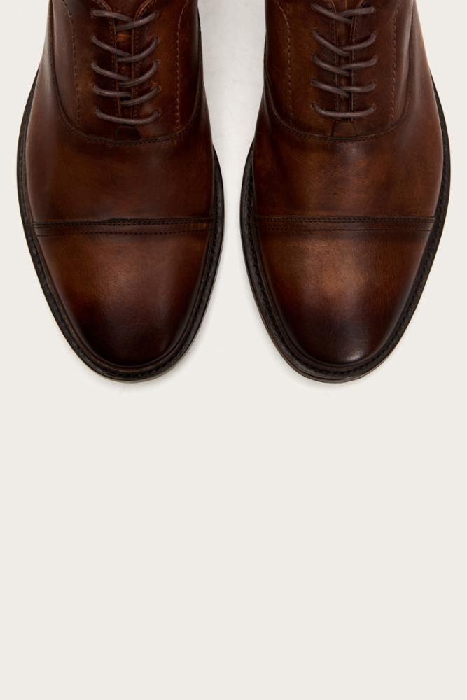 Pair of brown leather dress shoes with lace-up closure.