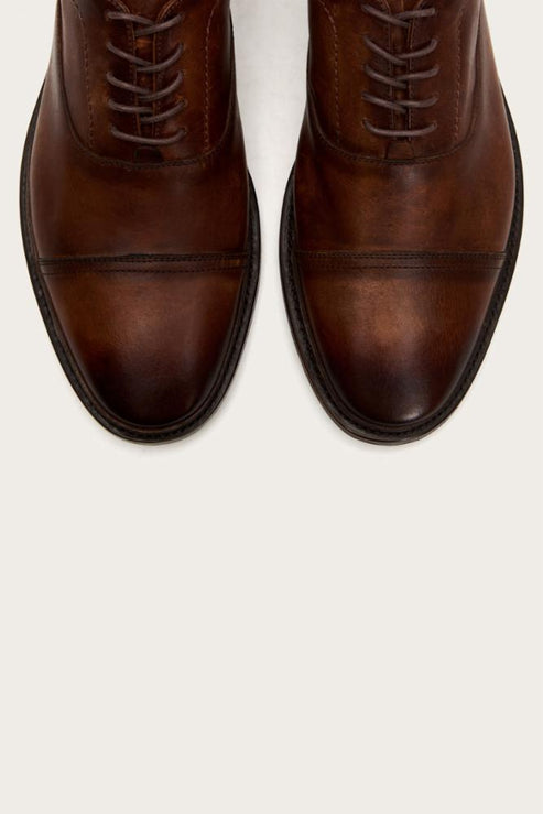 Pair of brown leather dress shoes with lace-up closure.