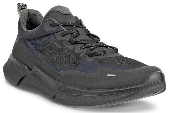 A black sneaker with gray laces, a gray lining, and a thick, cushioned sole.
