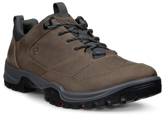 A brown leather, low-cut waterproof hiking shoe with gray laces, a dark gray padded collar, and a thick, black, lugged rubber sole with small red accents.