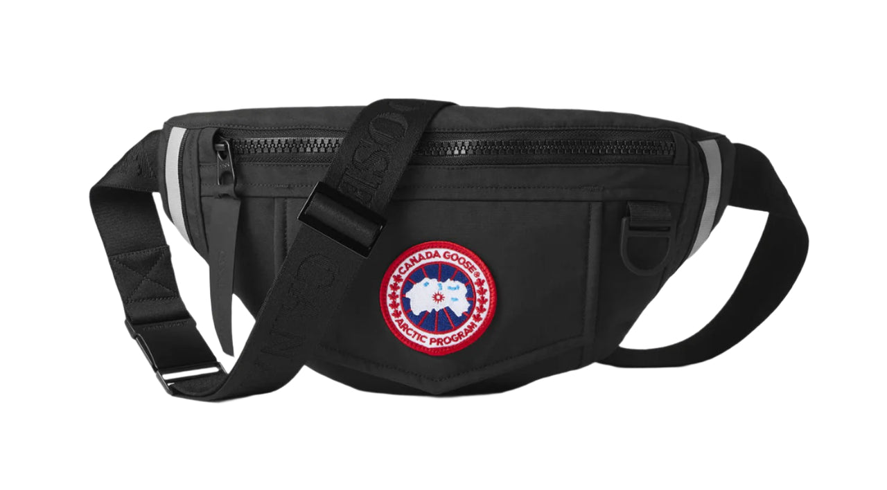 Black fanny pack with a strap and a round logo patch.