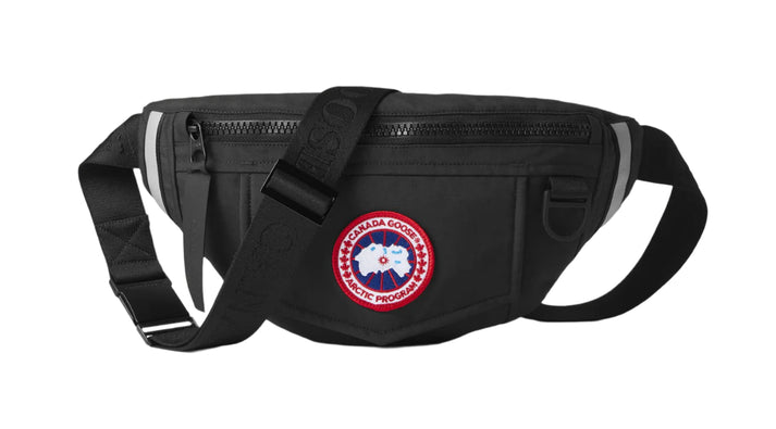 Black fanny pack with a strap and a round logo patch.