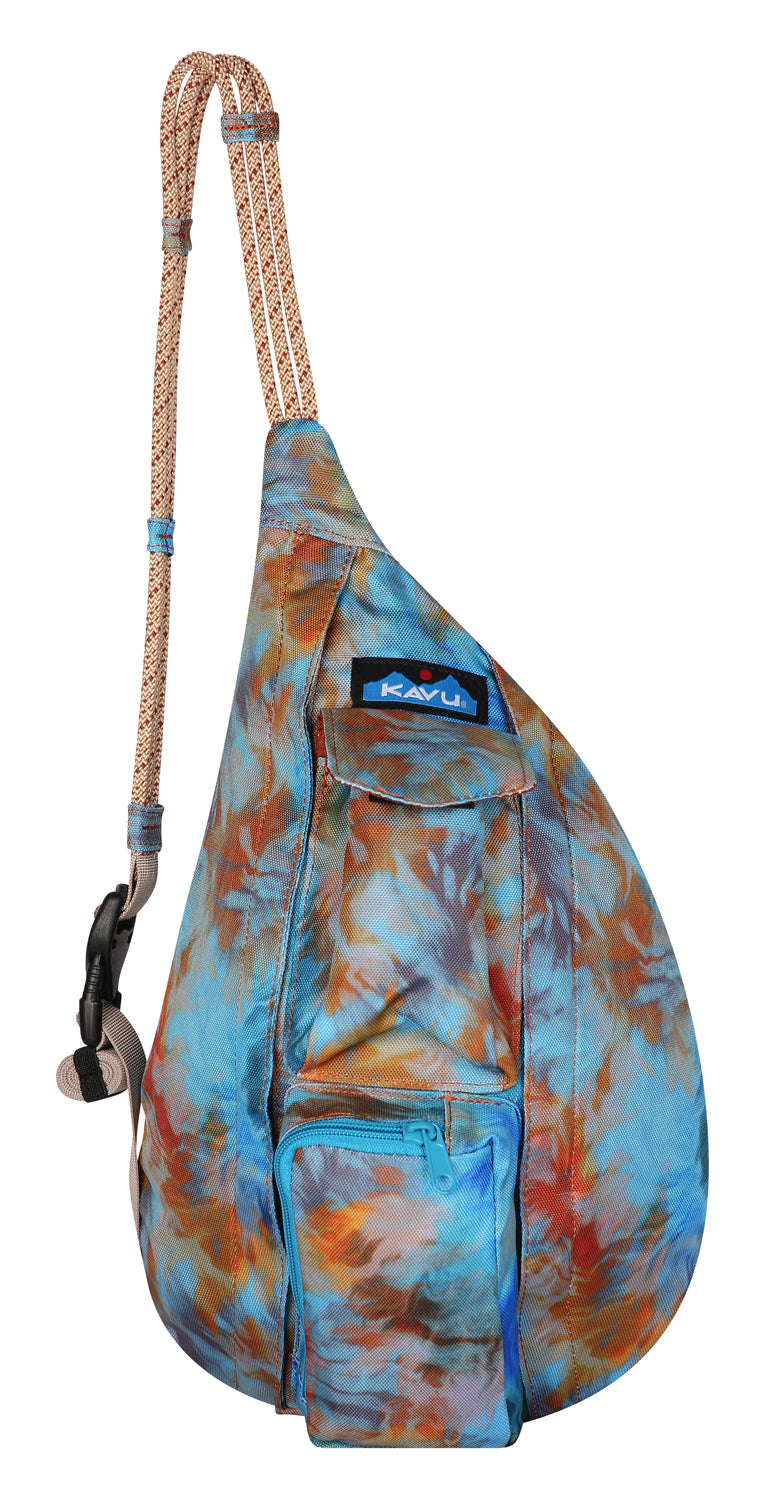 A teardrop shaped sling bag with a roped shoulder strap features blue, brown, and orange tie dye pattern and multiple pockets.