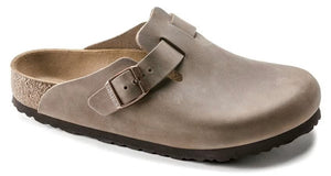 Slip-on clog shoe in taupe with an adjustable strap.