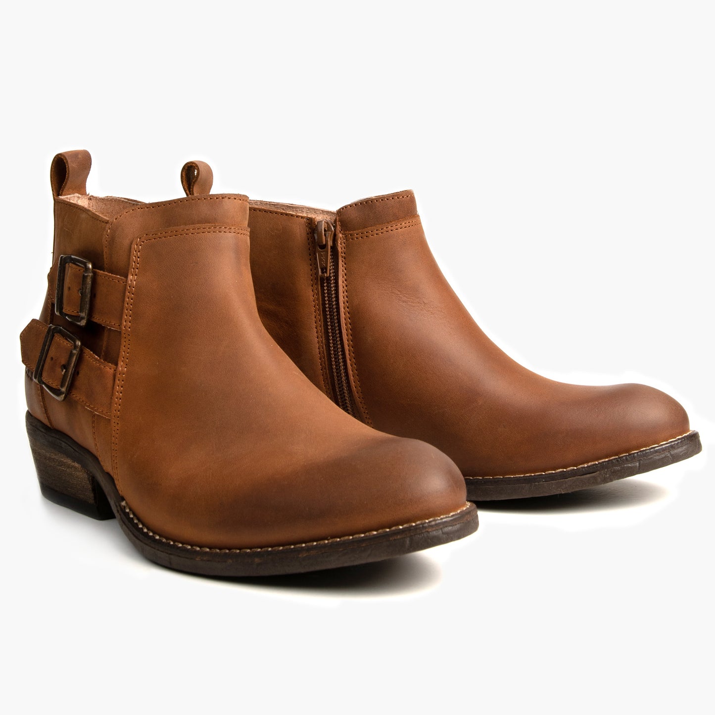 Pair of tan leather ankle boots, one with side zip, the other with buckles.