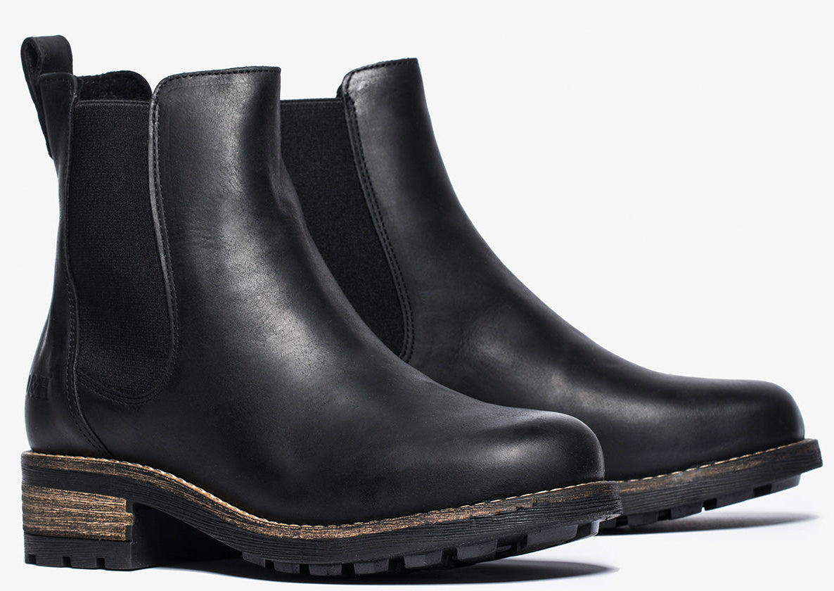 Pair of black leather Chelsea boots with low heel and elastic side panels.