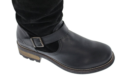 Close-up of black leather boot with buckled strap and slouchy suede upper.