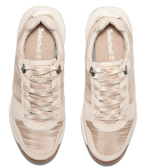 Two tan-colored sneakers with laces and metal eyelets, viewed from above, with the logo visible on the insole.
