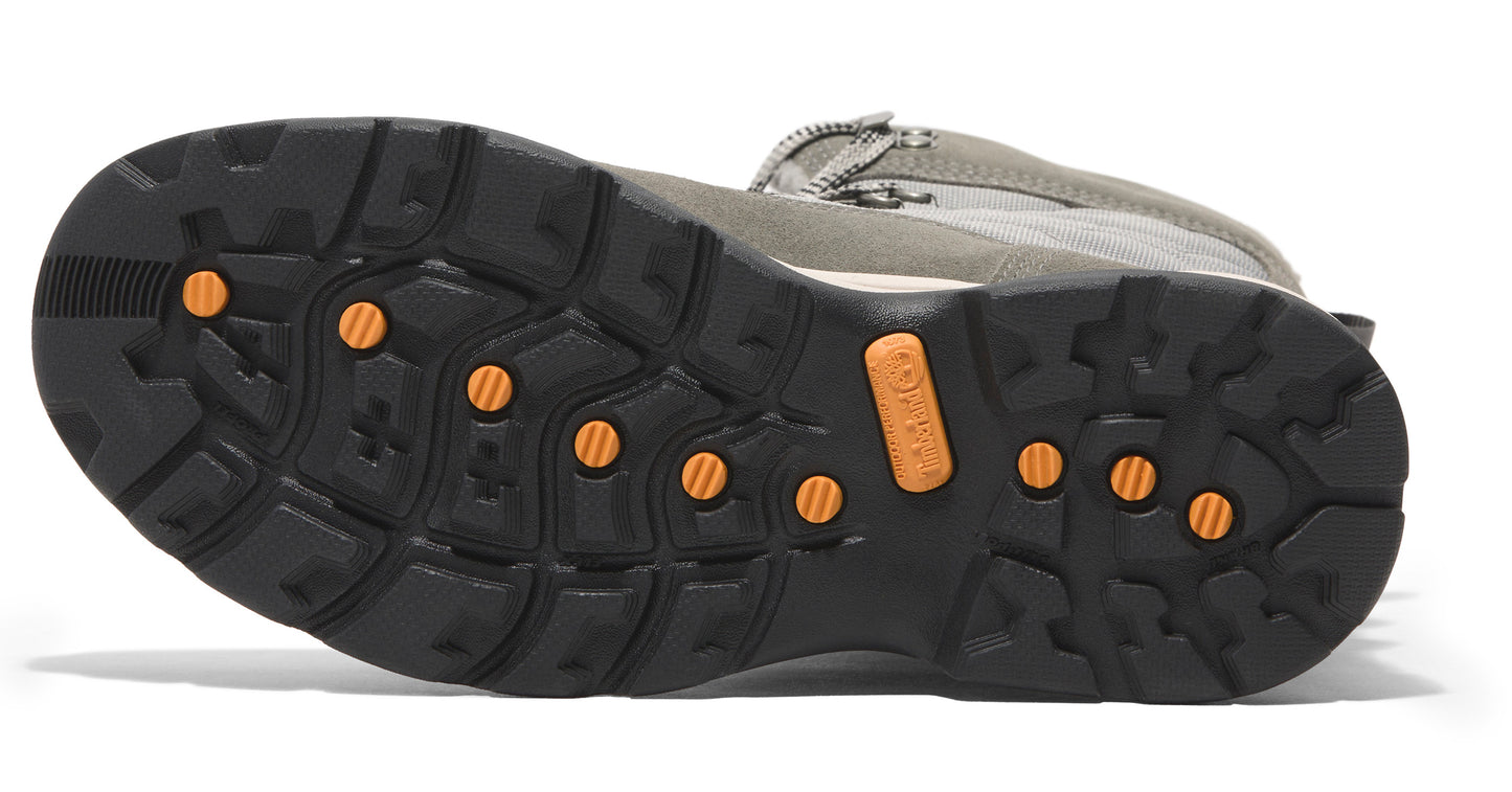 Bottom view of a boot revealing a black, lugged sole with orange circular inserts.