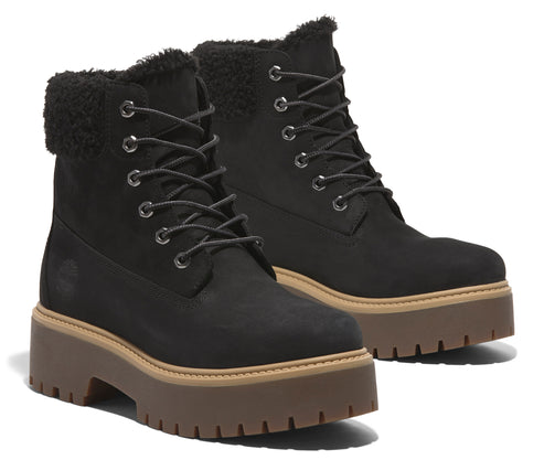 A pair of black ankle-high boots with a brown platform sole and furry trim around the top.