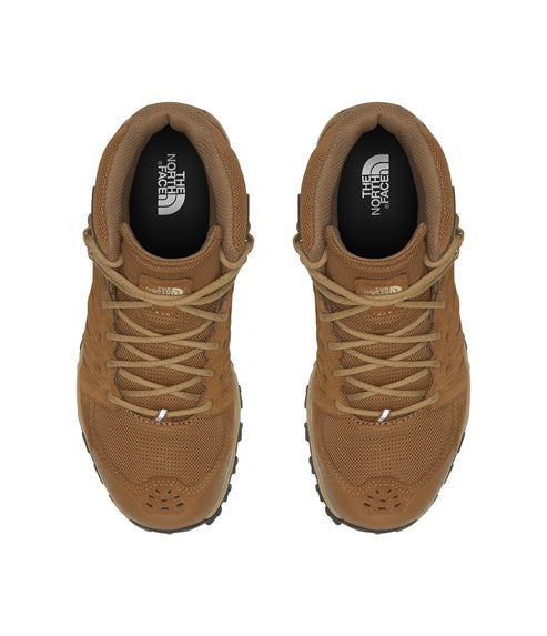 Pair of tan mid-height boots with laced closure, textured side panels, and visible logos inside.