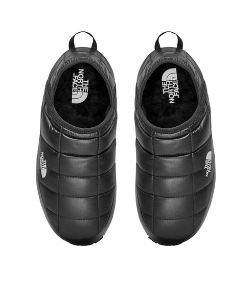 Overhead view of a pair of black quilted slip-on shoes with a loop at the heel.