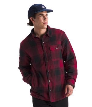 A man in a red and black flannel shirt and blue hat.