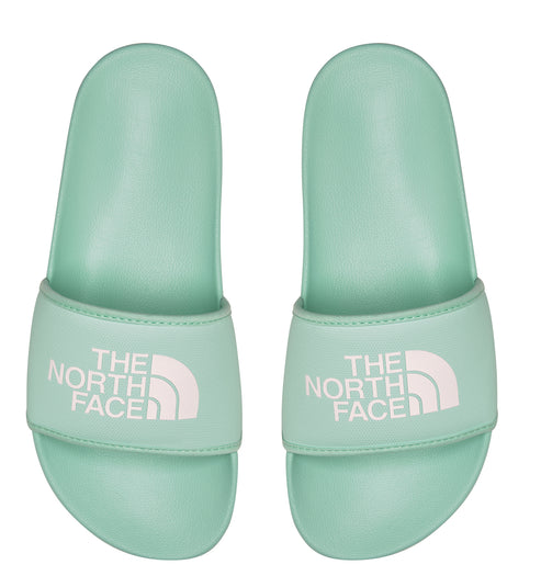 A pair of teal slides with 'THE NORTH FACE' printed in white.
