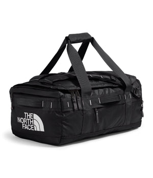 Black duffel bag with top carrying handles and adjustable shoulder straps, and logo 'THE NORTH FACE' on the side.