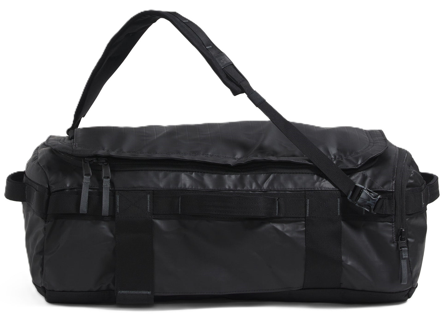 A black duffel bag with a shoulder strap is lying down.