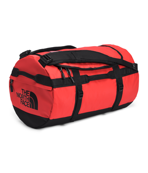 Red duffel bag with black straps and black text 'THE NORTH FACE' on one end.