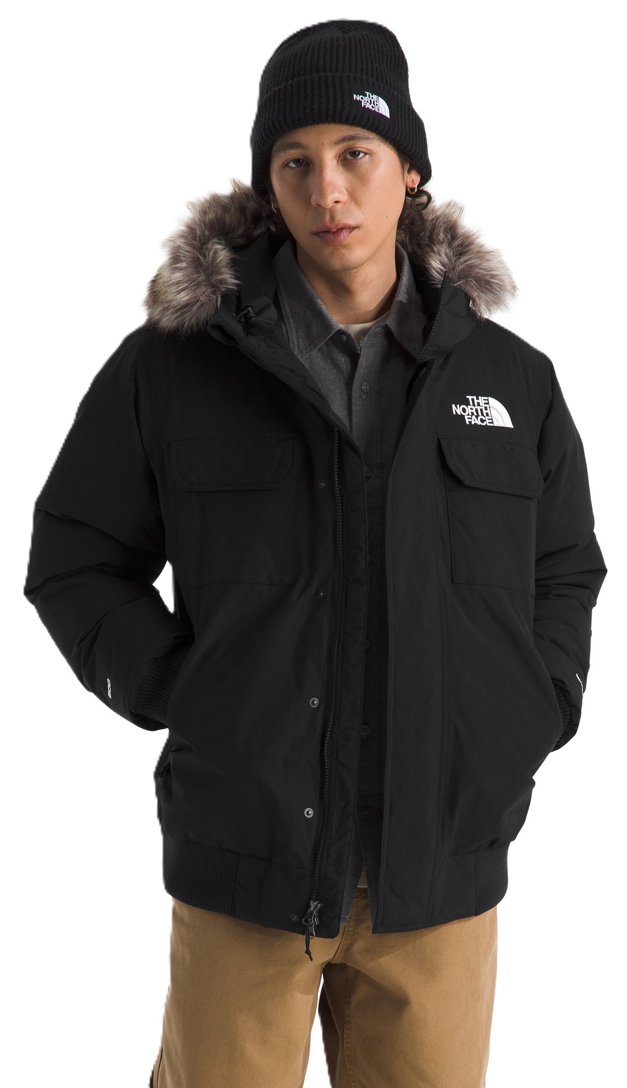 Man in a black jacket with fur hood trim and a beanie.