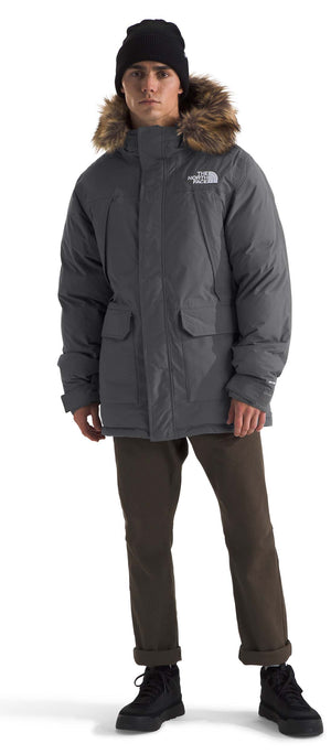 A person in a gray parka with a fur hood and black beanie.