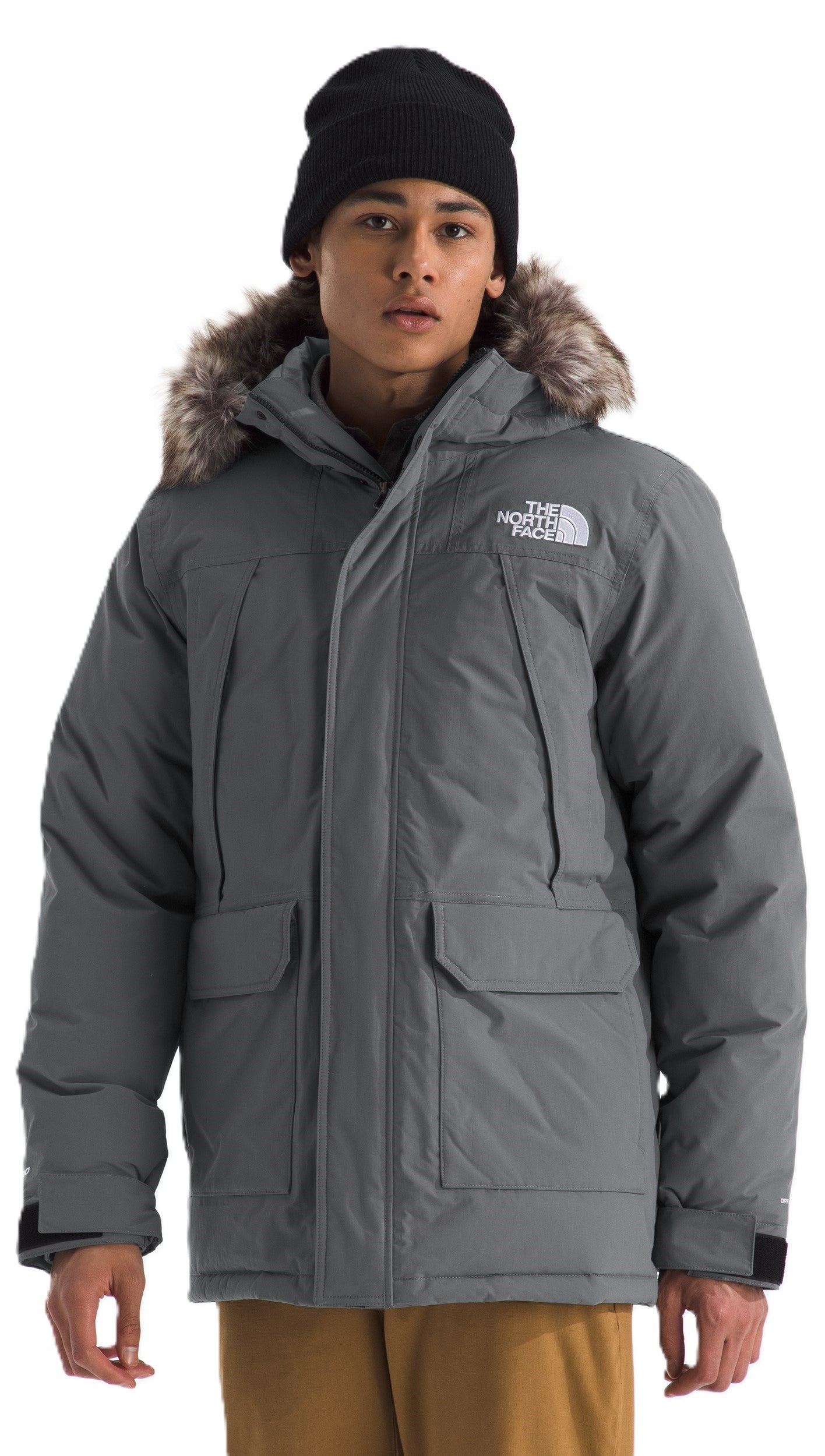 A man wearing a gray, fur-trimmed parka and black beanie.