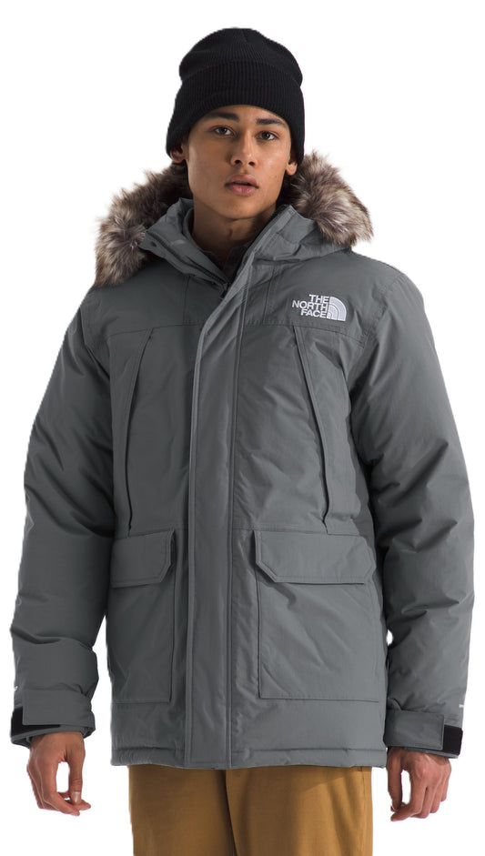 A man wearing a gray, fur-trimmed parka and black beanie.