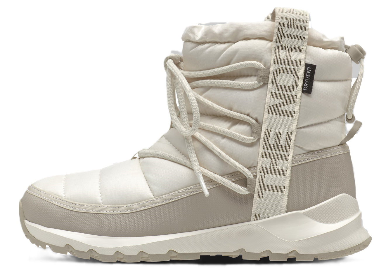 Beige quilted ankle boot with a textured white sole, decorative beige pull tab with "THE NORTH FACE" text.