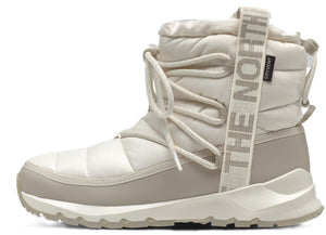 Beige quilted ankle boot with a textured white sole, decorative beige pull tab with "THE NORTH FACE" text.