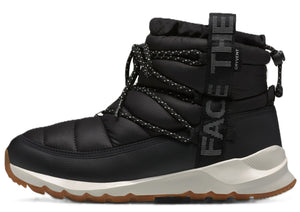 Black insulated puffy boot with laces and cream-colored sole, displaying the text "THE FACE" vertically.