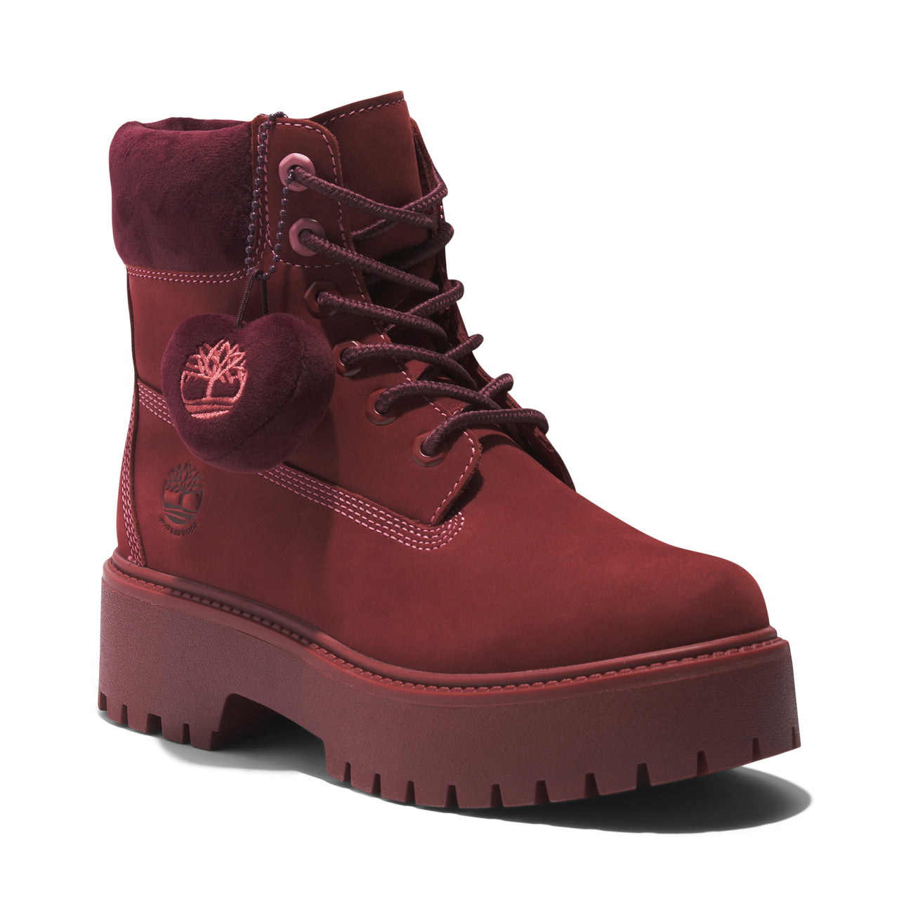 Platform lug-soled maroon boot with laces and a maroon plush decoration hanging off the side.