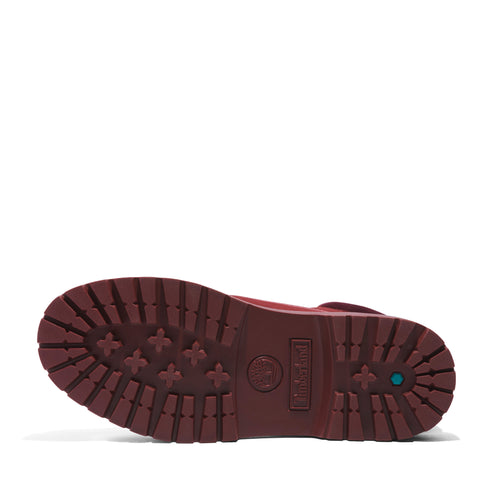 Sole of a lugged, maroon-colored boot. 