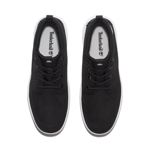 Overhead view of a pair of black canvas shoes with white soles and white interior with a Timberland logo.