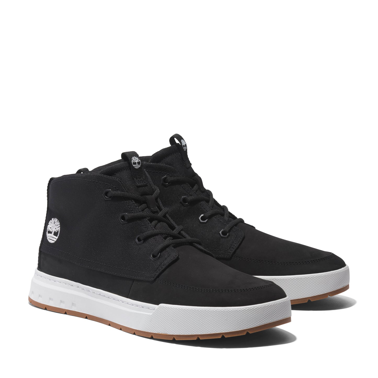 Pair of black canvas chukka shoes with white soles and brown outsoles.  Shoes are lace-up and have a logo on the side.