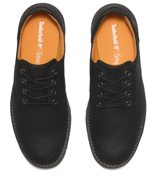 Overhead view of black lace-up shoes with light orange insoles that says, "Timberland OrthoLite".