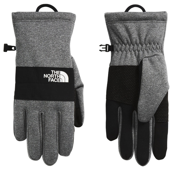 Pair of gray fleece gloves with a black band, THE NORTH FACE logo, black fingertips and adjustable wrist buckle.