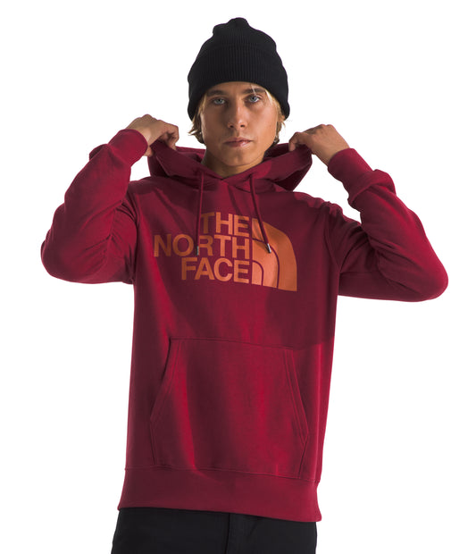 A person wearing a red hoodie with "THE NORTH FACE" in orange letters on the front, also wearing a black beanie.
