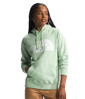 A woman wearing a light green hoodie with the words "THE NORTH FACE" printed in large white letters across the chest.