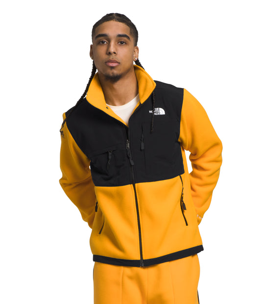 A person is wearing a yellow fleece jacket with a black chest and shoulders.