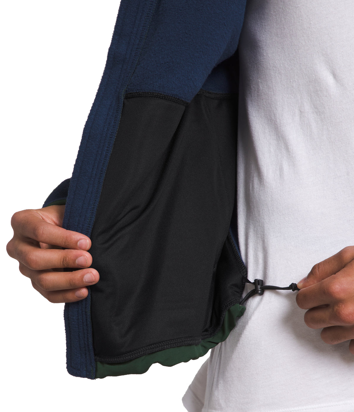 Close-up of a person adjusting the drawstring on the inside pocket of a blue and green jacket.