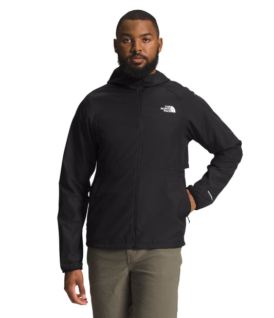 Man wearing black jacket with white logo over khaki pants.