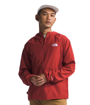 A model wearing a red jacket with a white logo on the chest and a white hat.