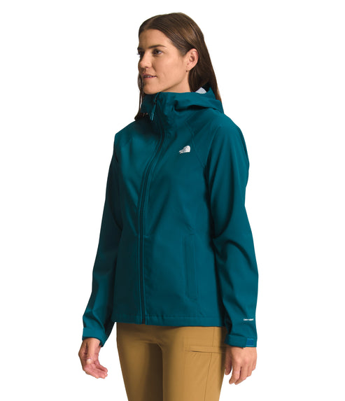 A woman wearing a teal rain jacket and khaki pants.