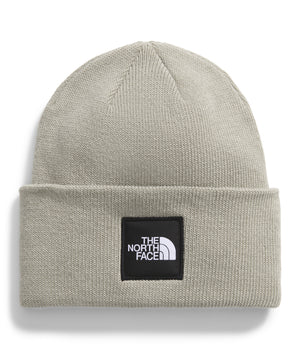 Grey knit beanie with a black square patch that says "THE NORTH FACE" in white text above a white logo.